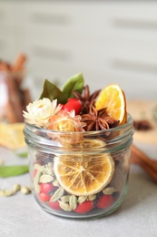 Photo of Aromatic potpourri in glass jar on light table