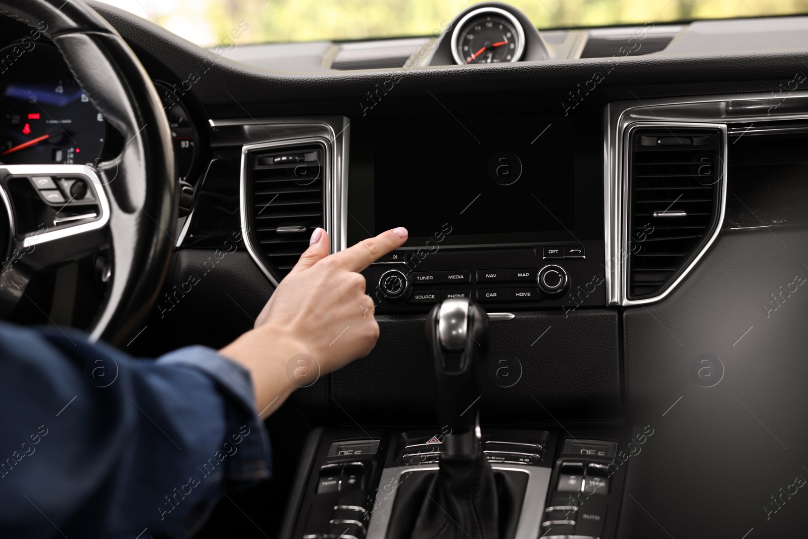 Photo of Woman using navigation system while driving her car, closeup