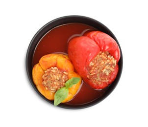 Photo of Delicious stuffed peppers with basil in bowl isolated on white, top view