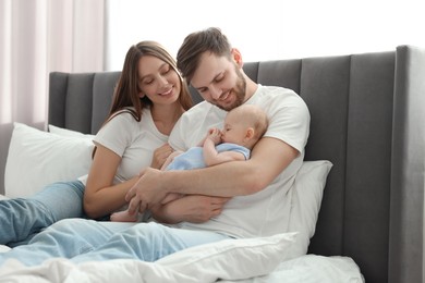 Happy family. Parents with their cute baby on bed indoors