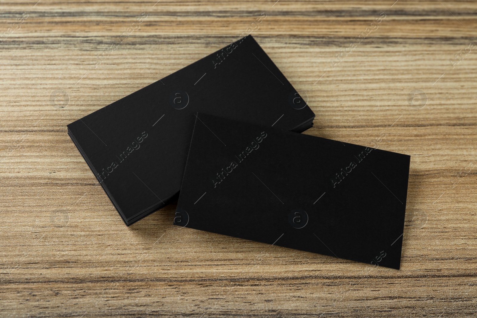 Photo of Blank black business cards on wooden background, above view. Mockup for design