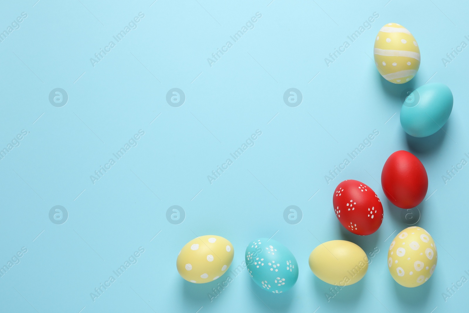 Photo of Flat lay composition with painted Easter eggs on color background, space for text