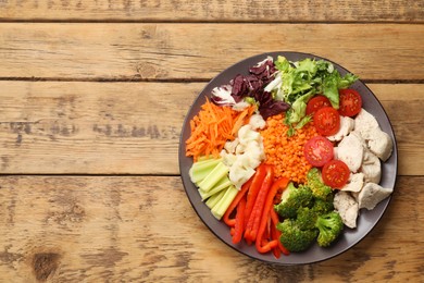 Photo of Balanced diet and healthy foods. Plate with different delicious products on wooden table, top view. Space for text