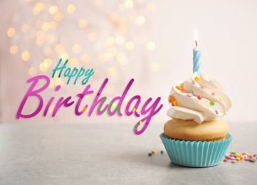 Image of Text Happy Birthday and delicious cupcake with candle on blurred background