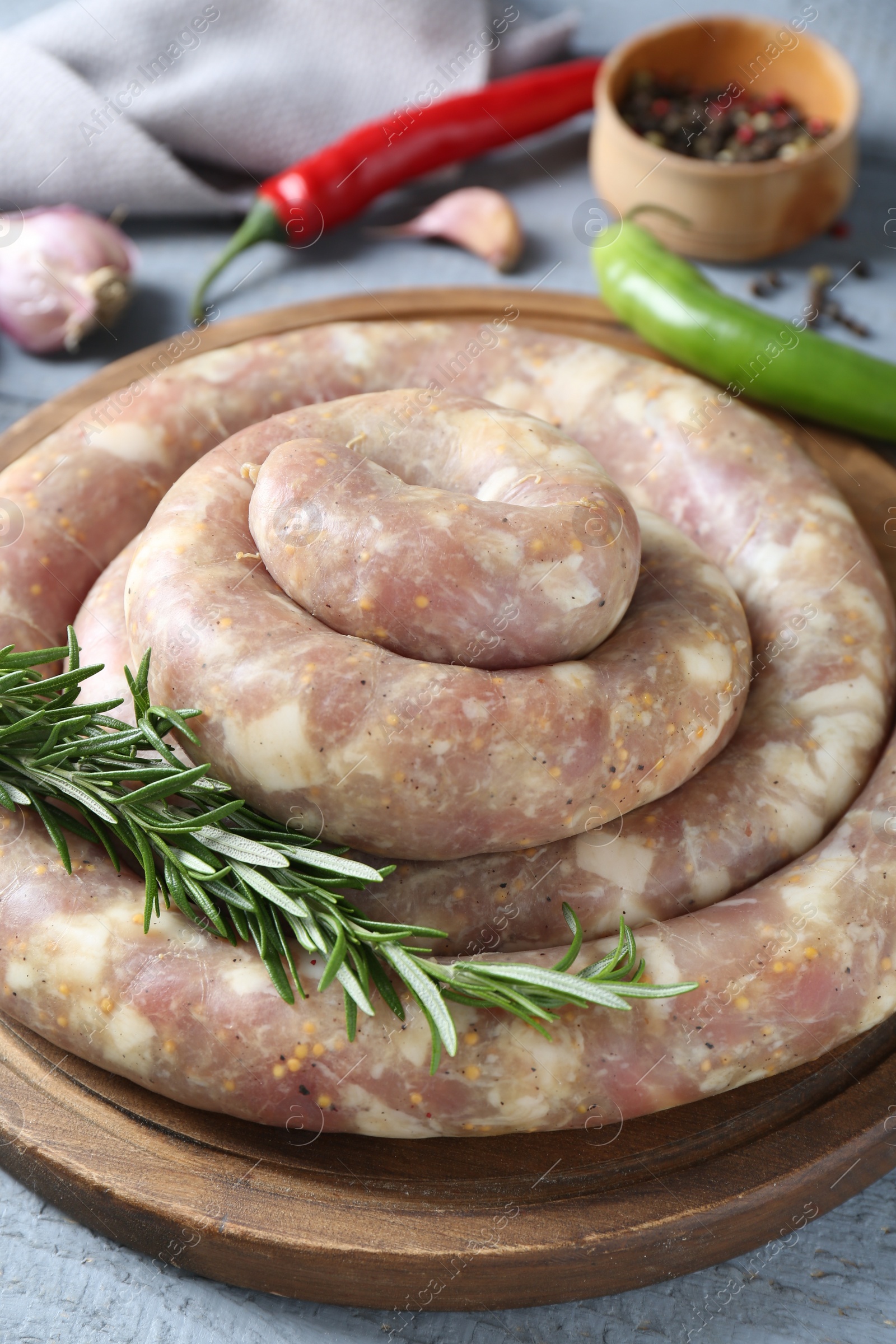 Photo of Homemade sausages and products on light grey wooden table, closeup