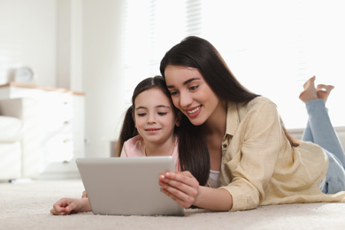 Mother and daughter reading E-book together at home
