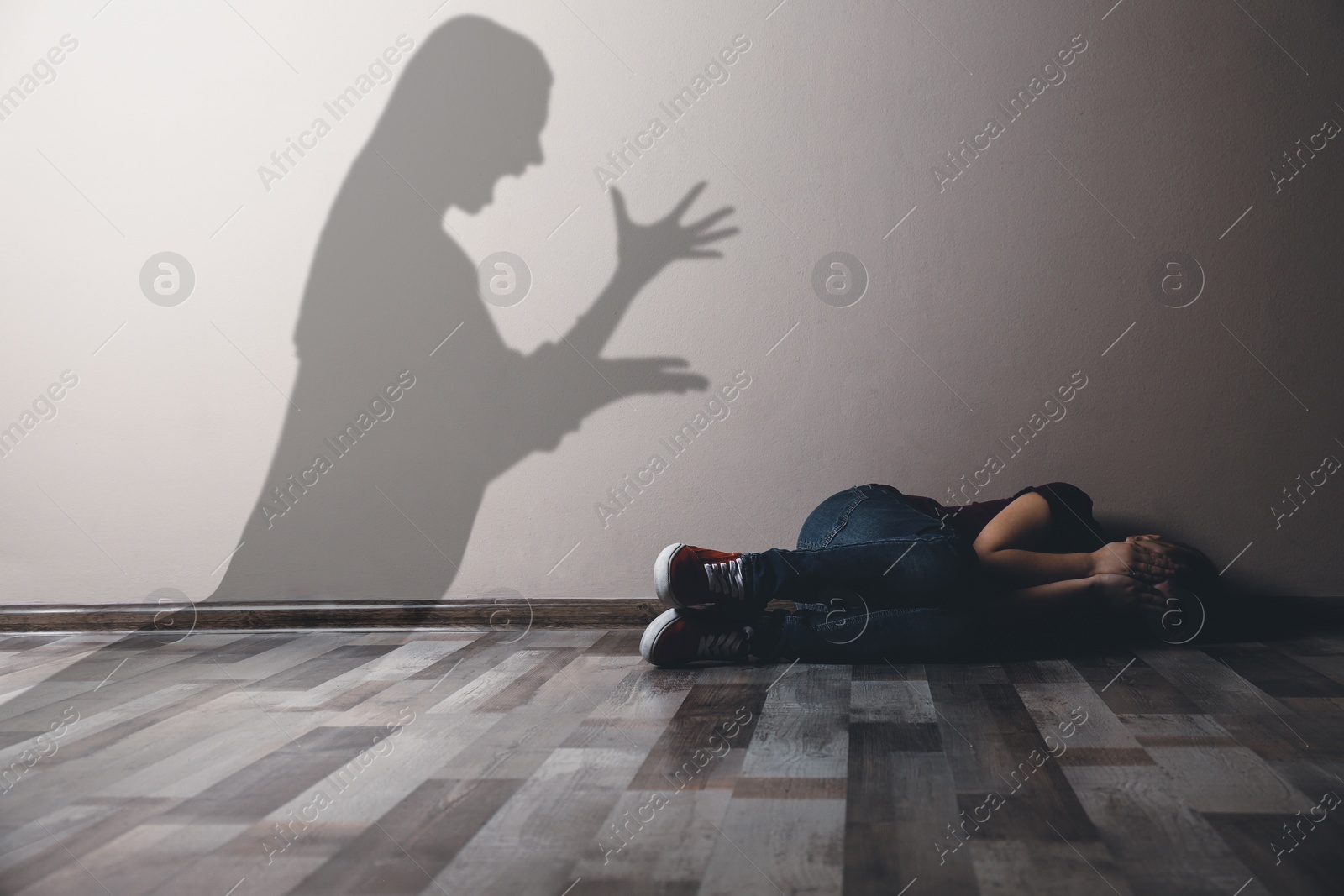 Image of Child abuse. Mother yelling at her daughter. Shadow of woman on wall