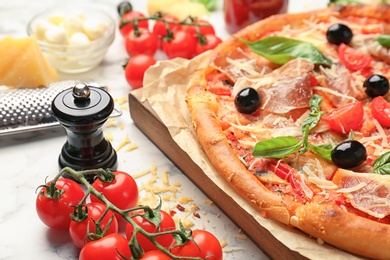 Photo of Delicious pizza with tomatoes and meat  on table, closeup