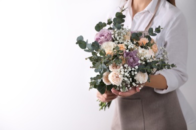 Florist holding beautiful wedding bouquet on white background, closeup