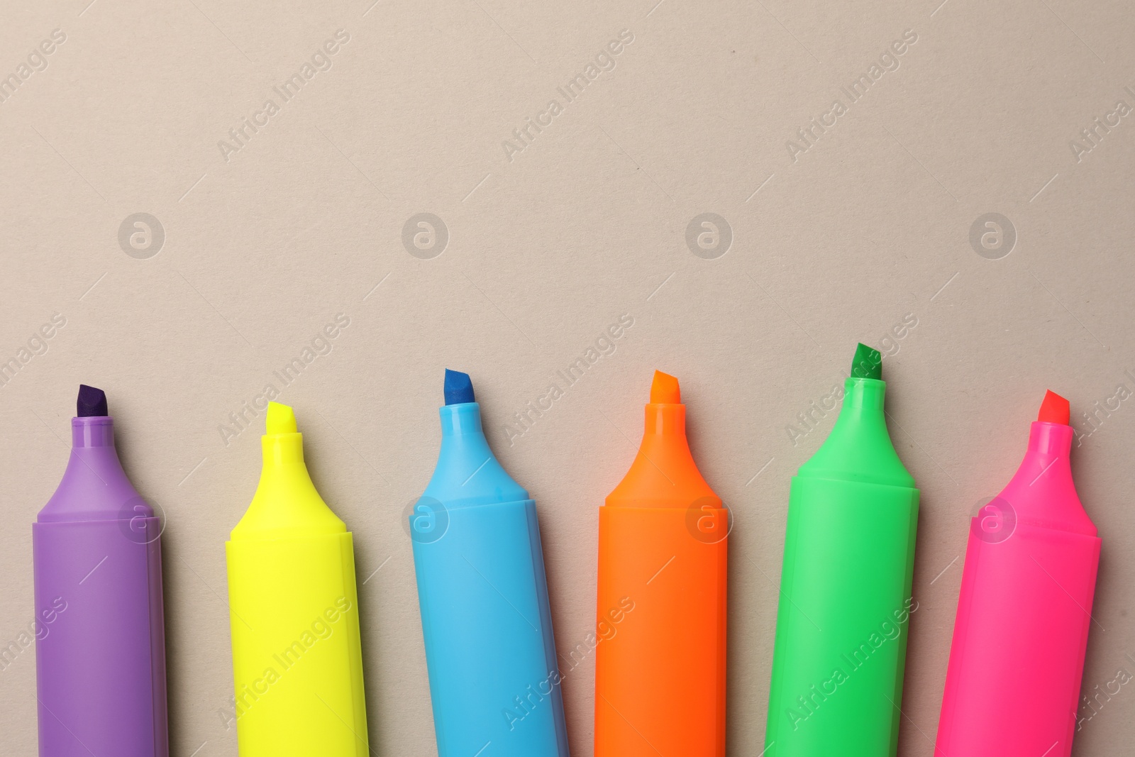 Photo of Bright color markers on light grey background, flat lay. Space for text