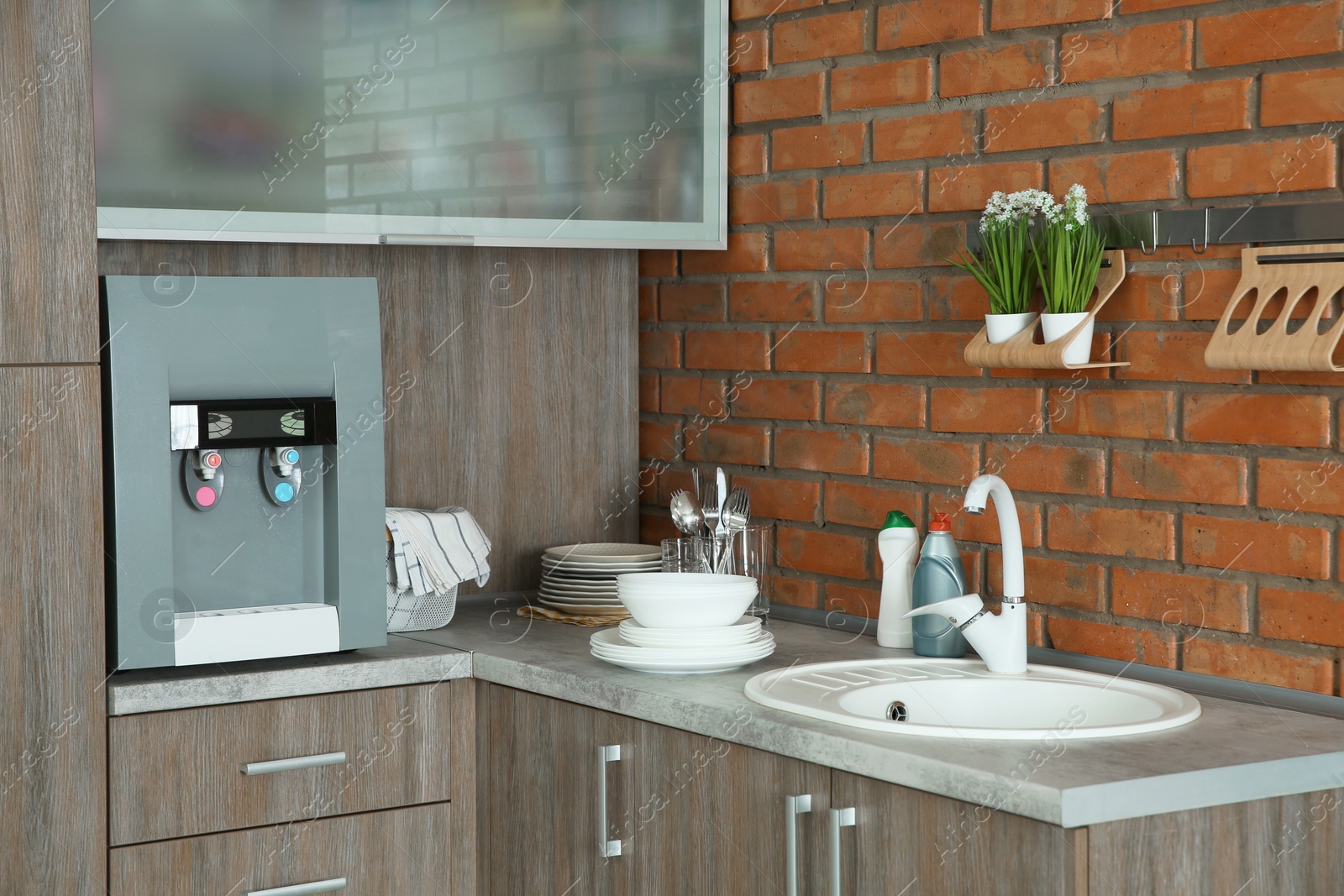 Photo of Kitchen counter with water cooler, sink and clean dishes, indoors