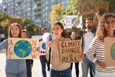 Photo of Group of people with posters protesting against climate change on city street