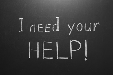 Phrase "I need your help" written on chalkboard