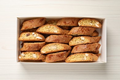 Photo of Traditional Italian almond biscuits (Cantucci) on white wooden table, top view
