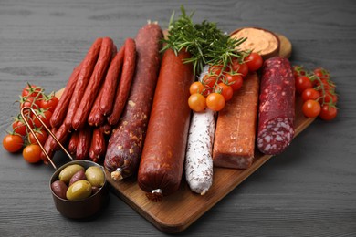 Different types of tasty sausages on grey wooden table