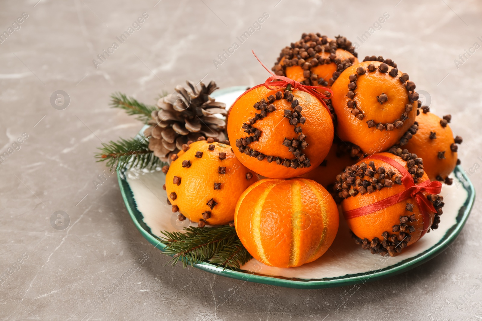 Photo of Pomander balls made of fresh tangerines and cloves grey table, space for text