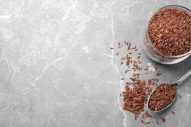 Photo of Brown rice on grey marble table, flat lay. Space for text