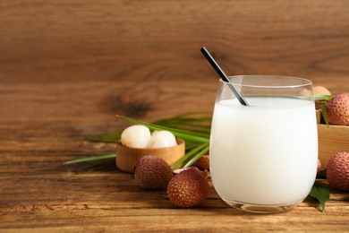 Lychee juice and fresh fruits on wooden table. Space for text