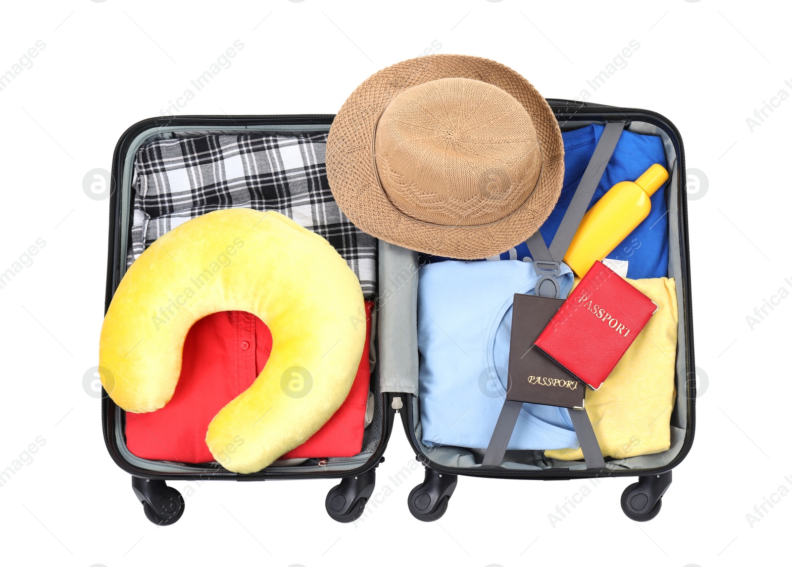 Photo of Soft travel pillow, hat, passports and other items in open suitcase isolated on white, top view