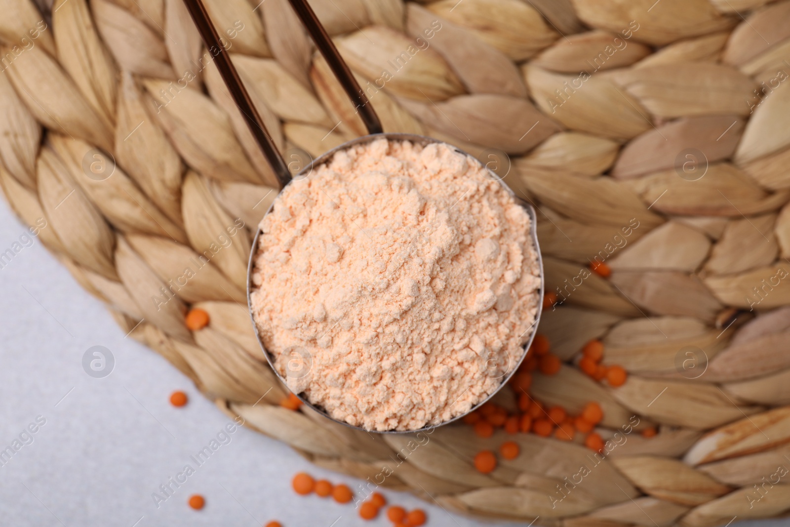 Photo of Organic lentil flour on wicker mat, flat lay