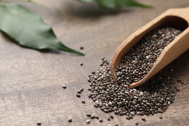 Scoop with chia seeds on wooden table, closeup. Space for text