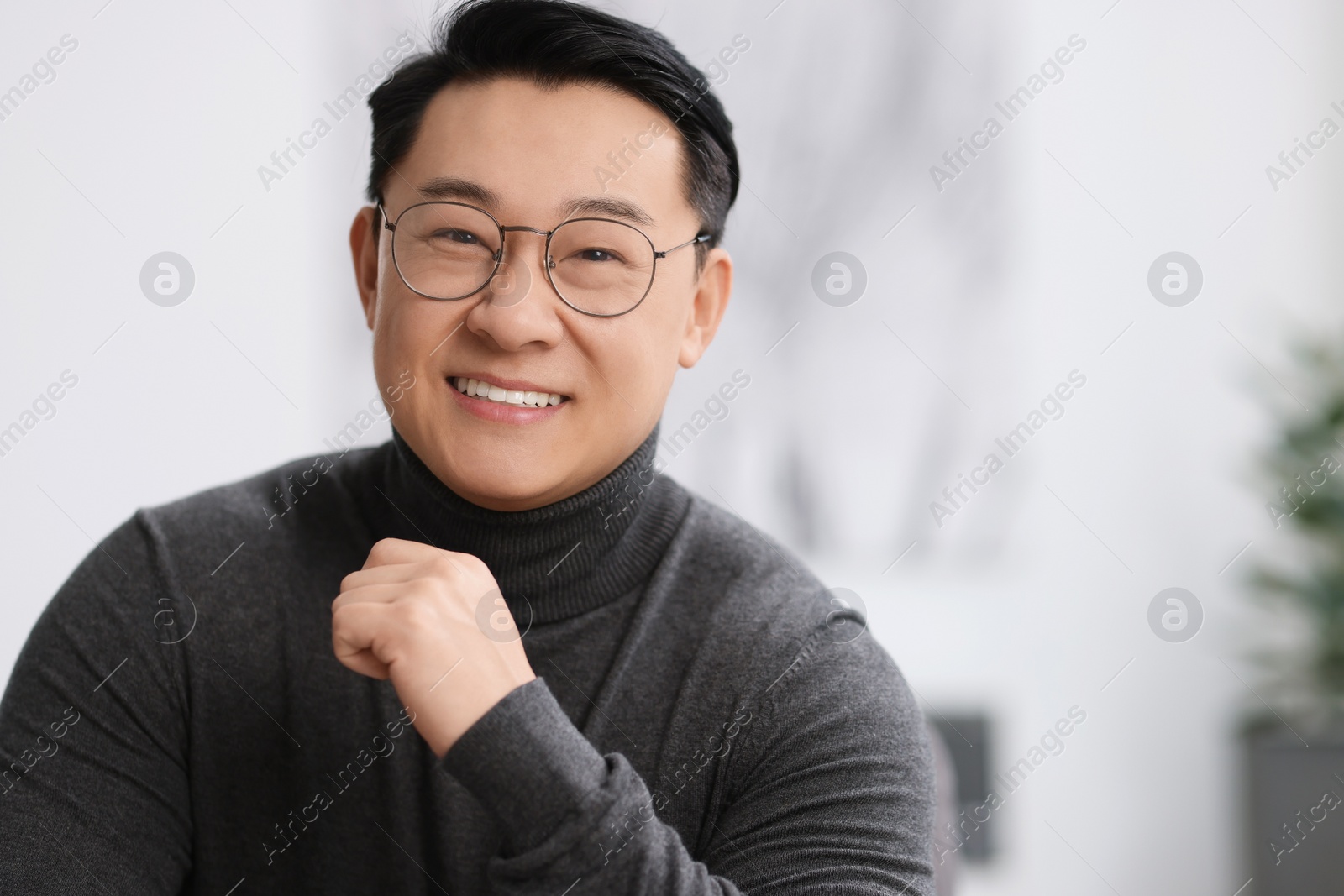 Photo of Portrait of smiling businessman on blurred background. Space for text