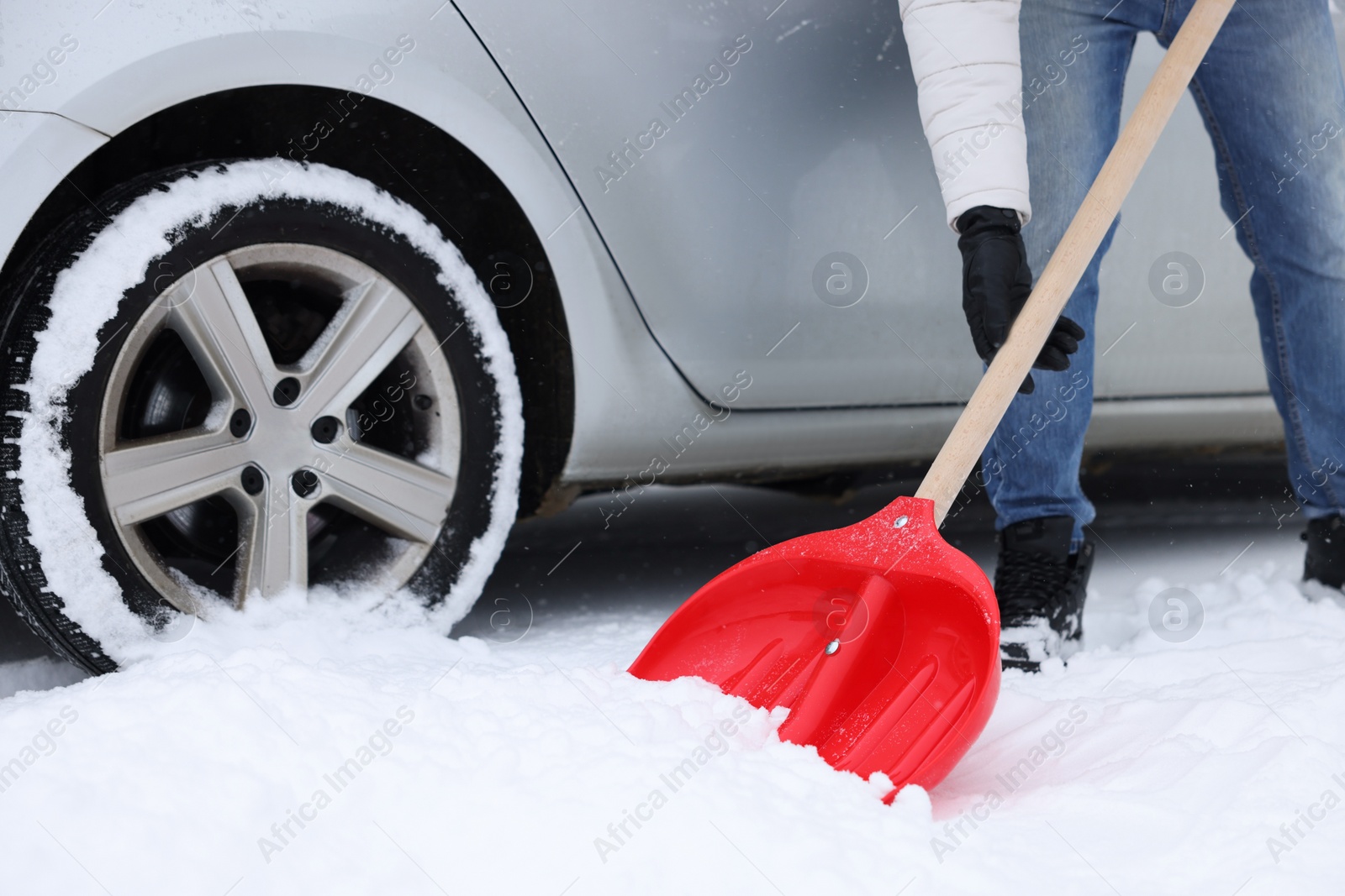 Photo of Man removing snow with shovel near car outdoors, closeup