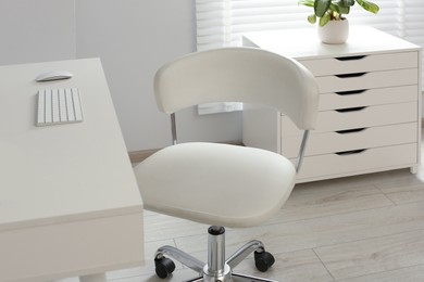 Photo of Stylish office chair at workplace in room. Interior design