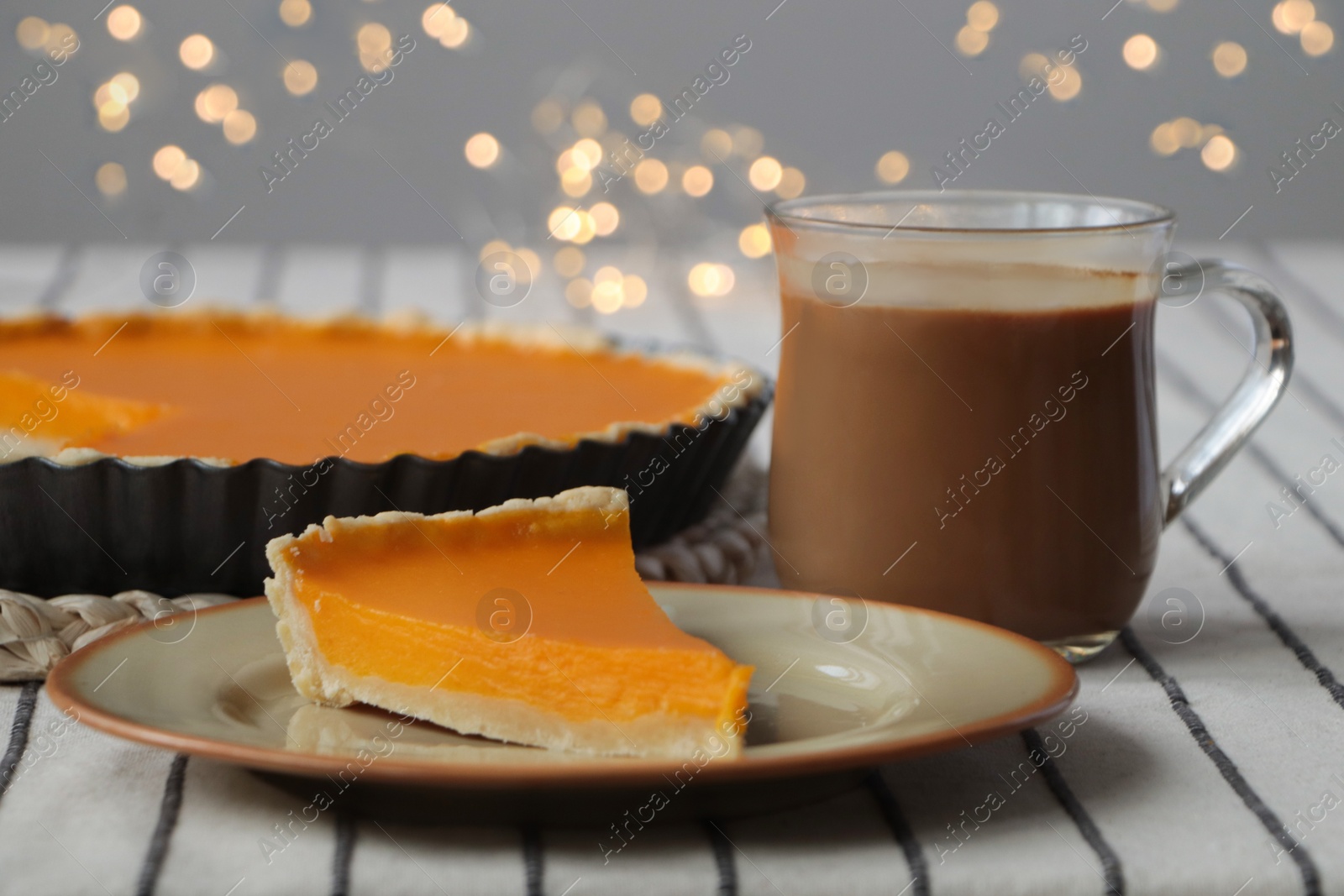 Photo of Piece of fresh homemade pumpkin pie served with cocoa on table