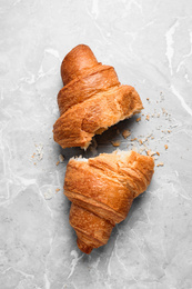 Photo of Tasty fresh croissant on light grey marble table, flat lay