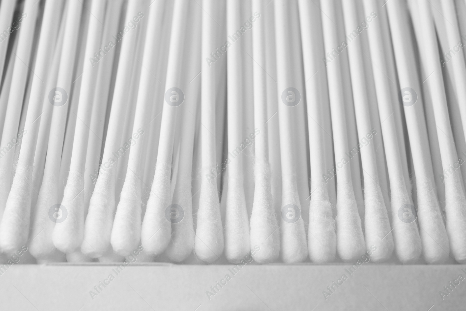 Photo of New cotton buds in cardboard box, closeup