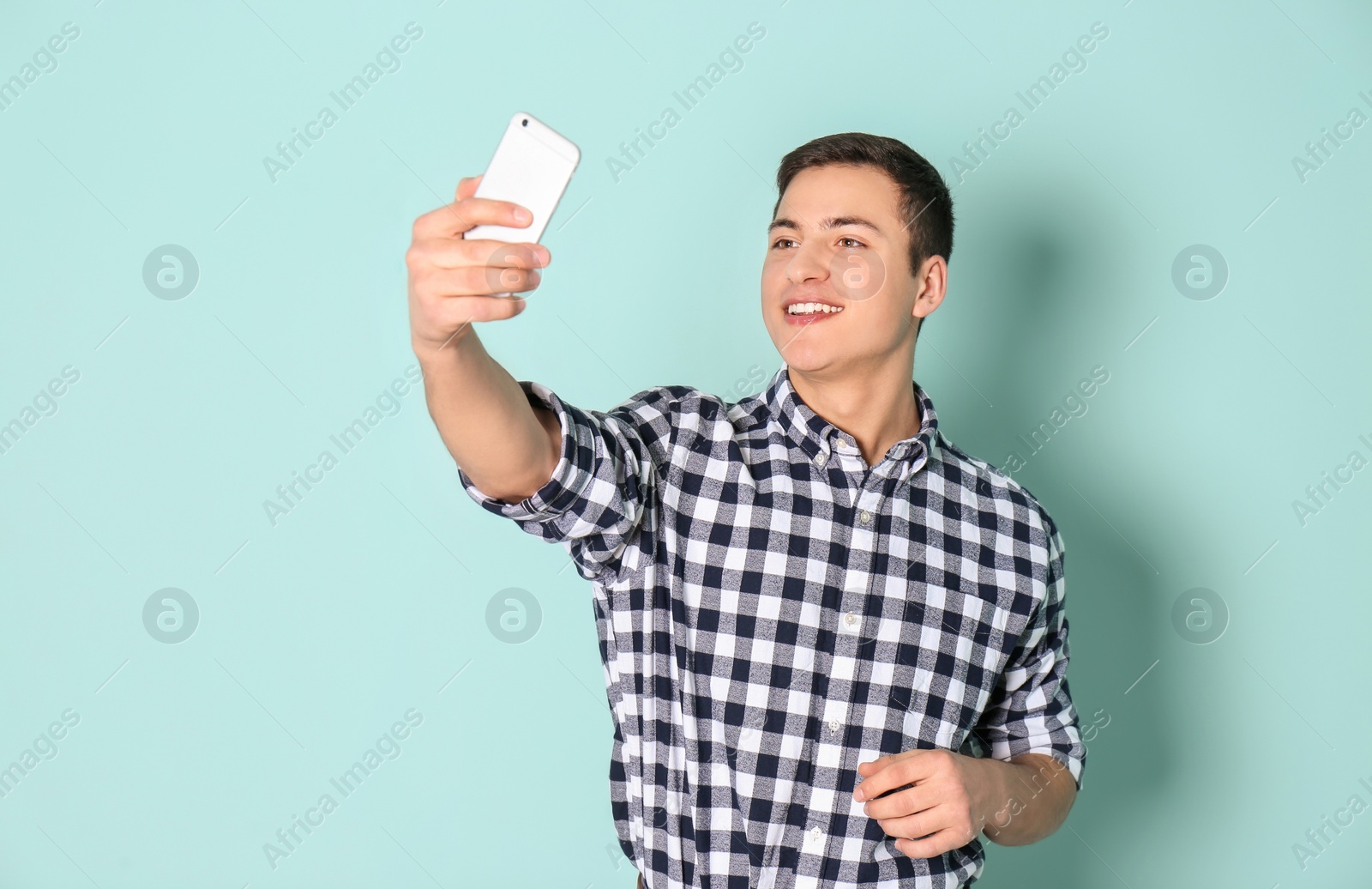 Photo of Young handsome man taking selfie against color background