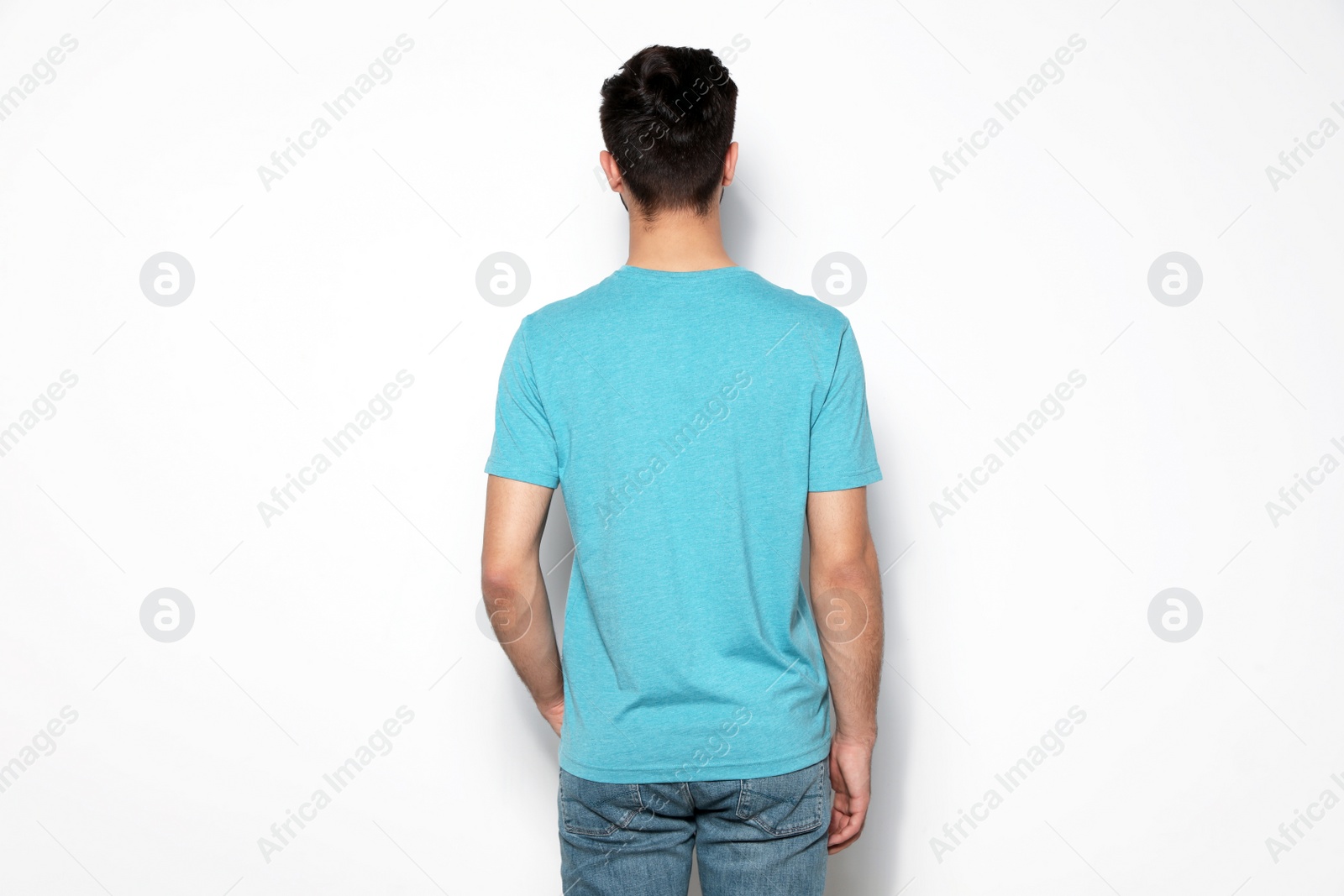 Photo of Young man in t-shirt on light background. Mock up for design