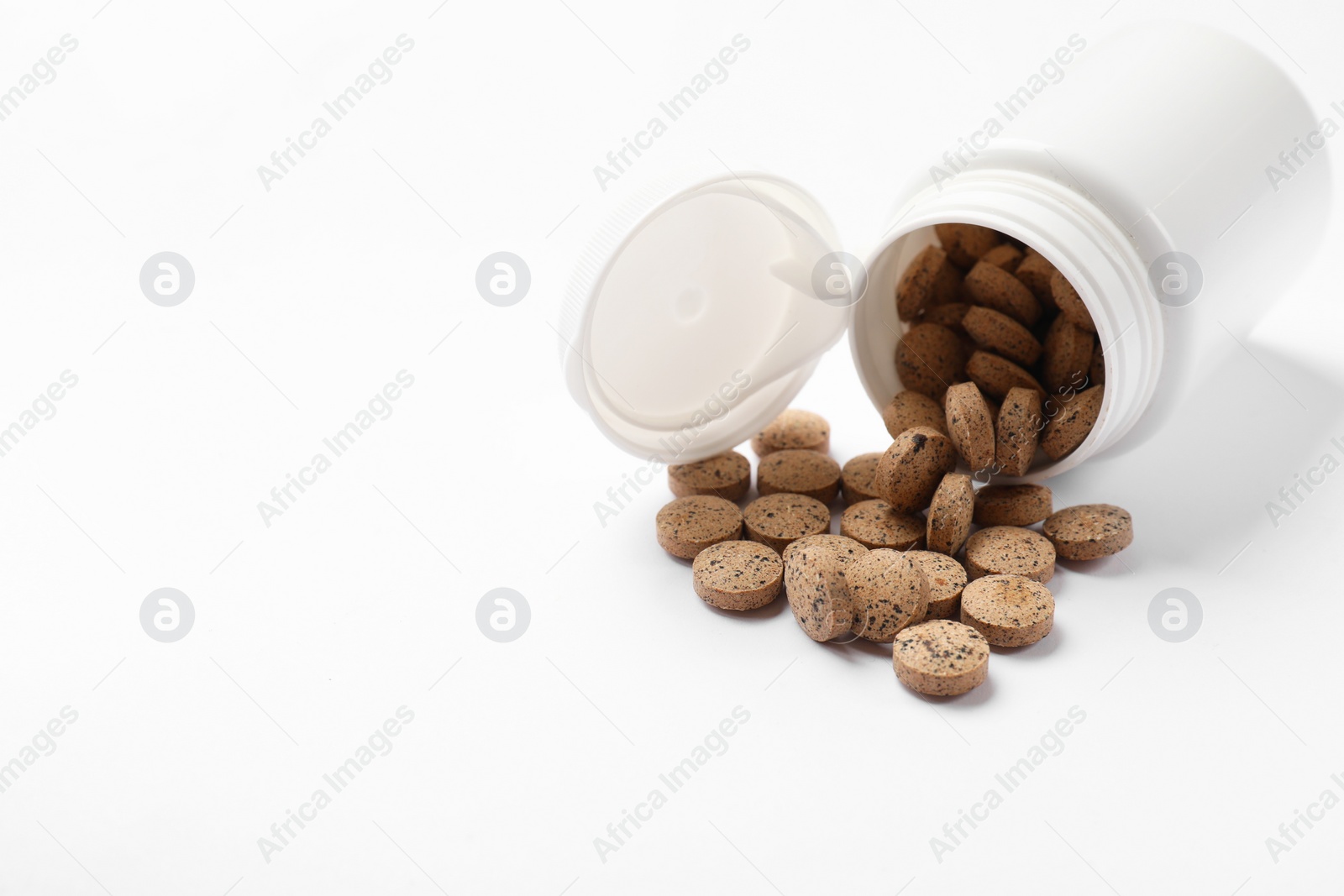 Photo of Bottle and vitamin pills on white background, space for text