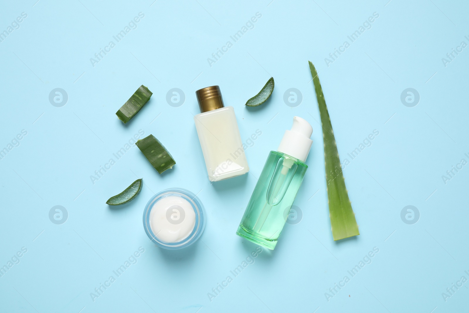 Photo of Flat lay composition with aloe vera and cosmetic products on light blue background