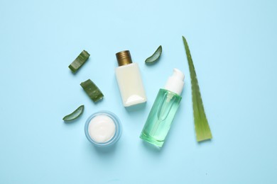 Flat lay composition with aloe vera and cosmetic products on light blue background