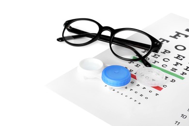 Case with contact lenses, glasses and eye chart test on white background