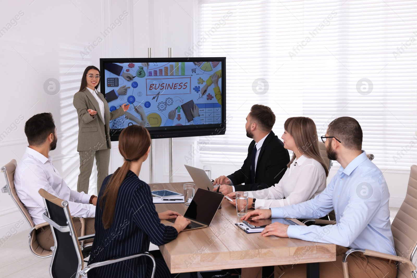 Photo of Business trainer using interactive board in meeting room during presentation