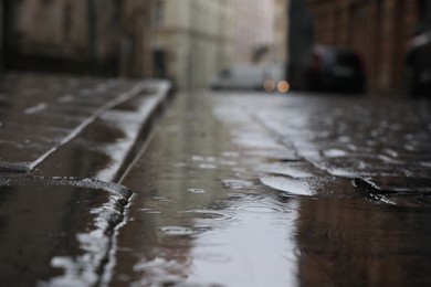 Photo of Rippled puddle on pavement on rainy day