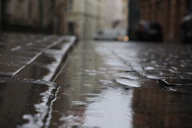 Rippled puddle on pavement on rainy day