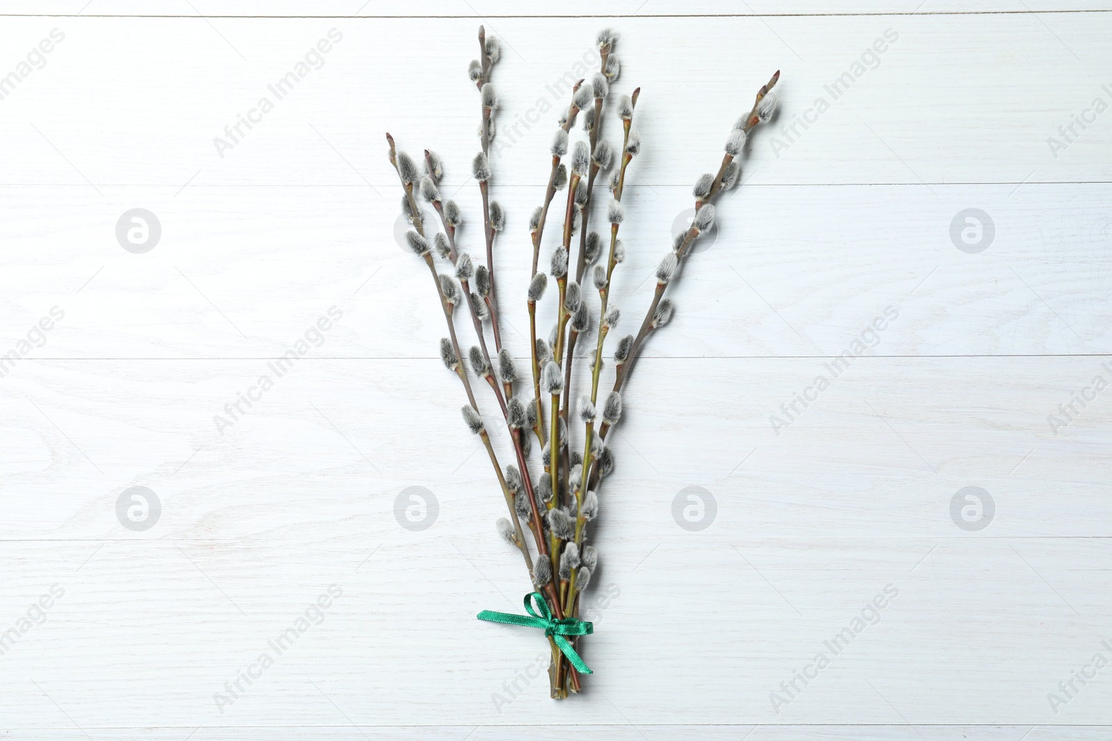 Photo of Beautiful bouquet of pussy willow branches on white wooden background, top view