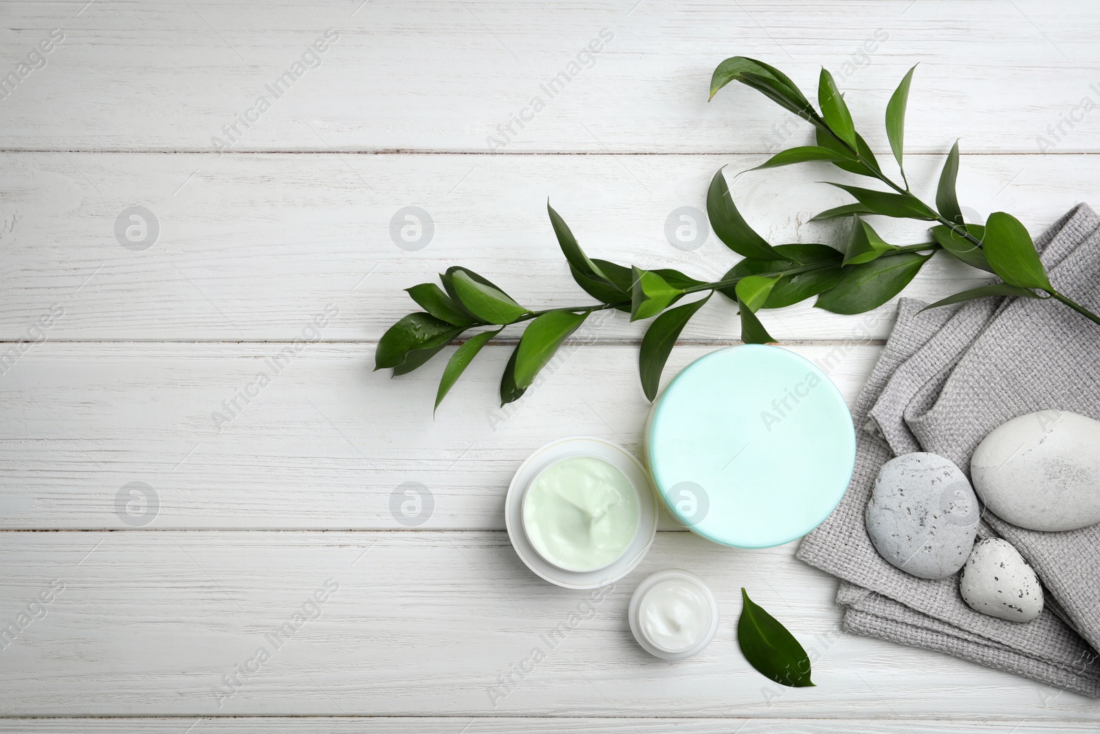 Photo of Composition with body cream in jars on wooden background, top view