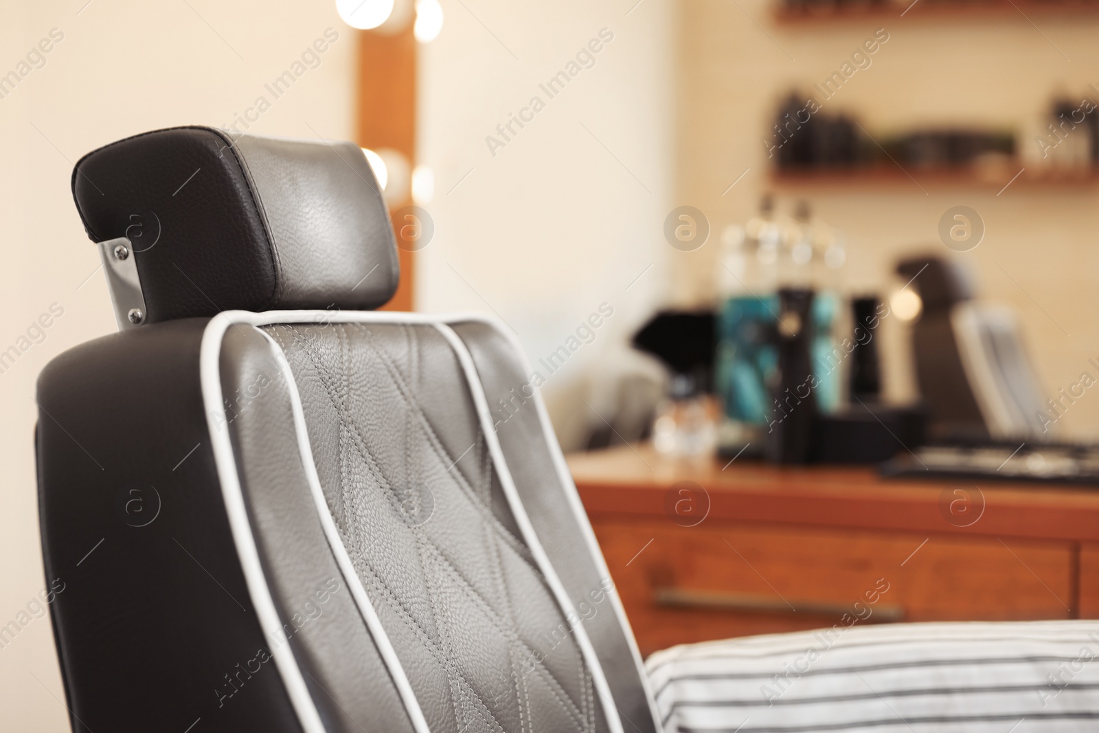 Photo of Closeup view of professional barber chair in hairdressing salon