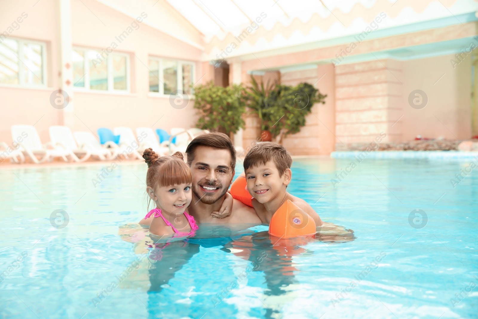 Photo of Happy father with children in swimming pool