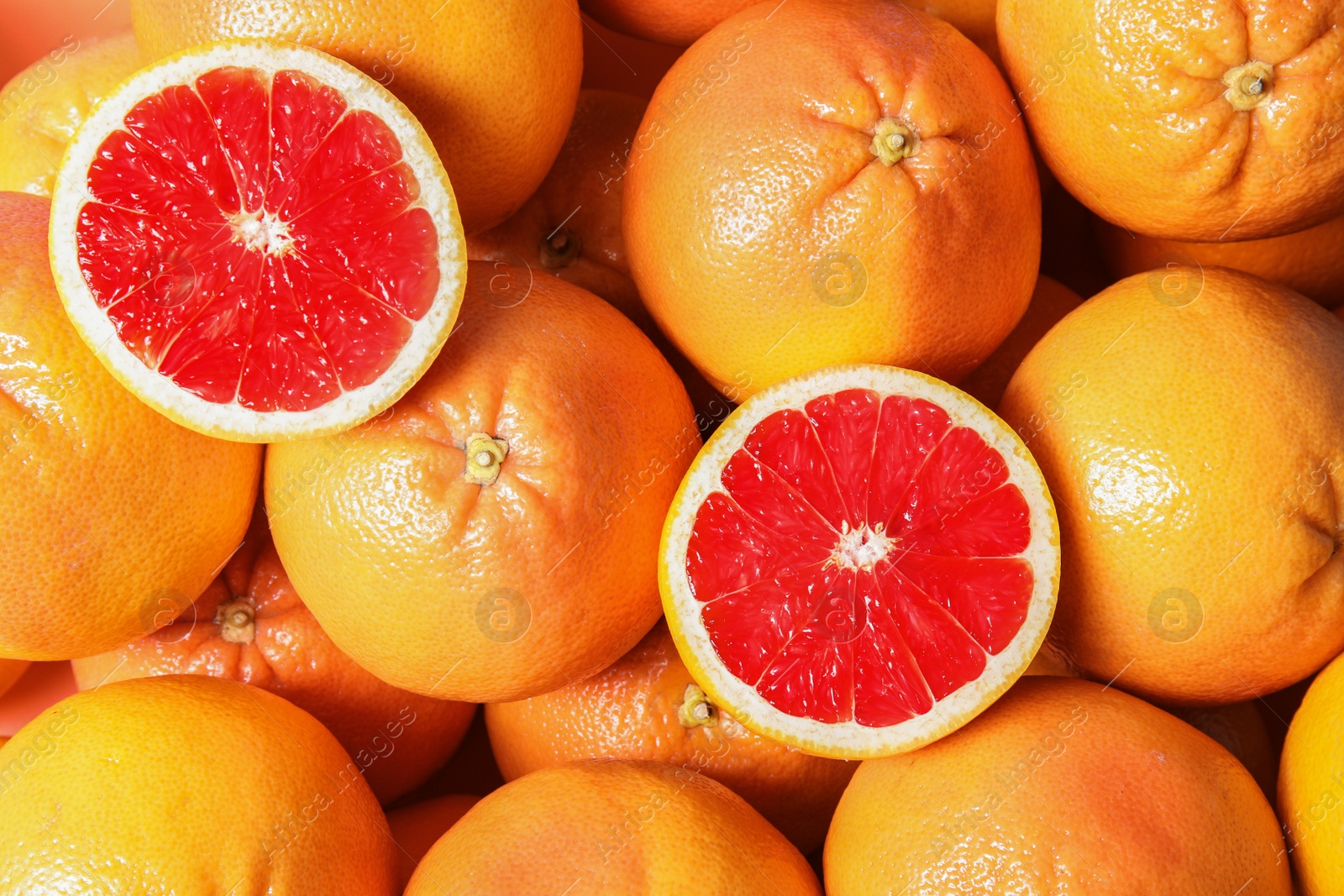 Photo of Many whole fresh ripe grapefruits as background, top view