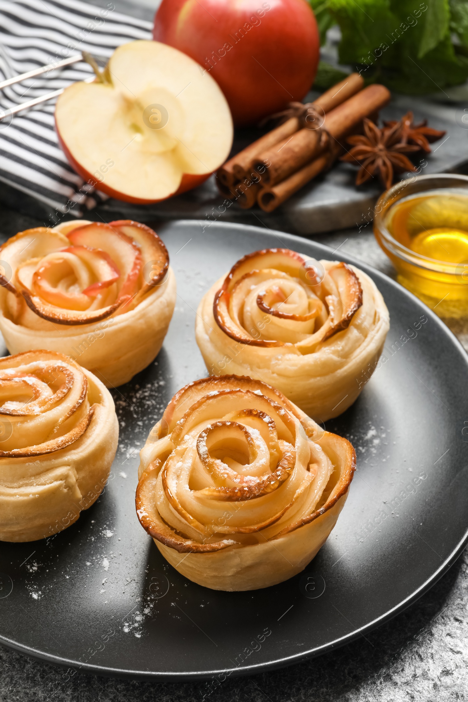 Photo of Freshly baked apple roses on grey table. Beautiful dessert