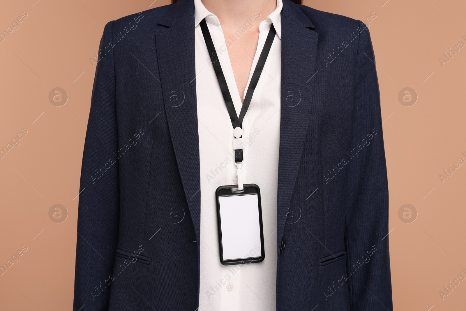 Photo of Woman with blank badge on light brown background, closeup