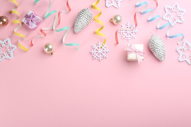 Flat lay composition with serpentine streamers and Christmas decor on pink background. Space for text