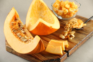 Cut fresh ripe pumpkin on grey background, closeup