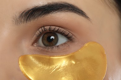 Young woman with golden under eye patch, closeup